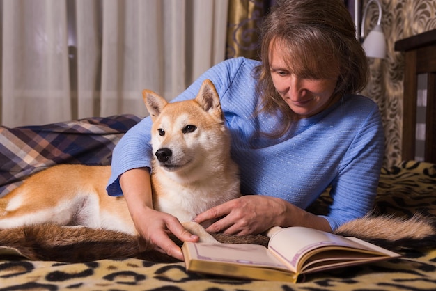 Une femme allongée sur le lit et lisant un livre