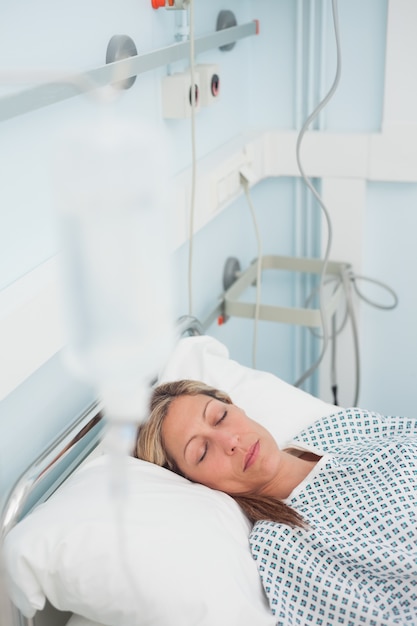 Femme allongée sur un lit médical en fermant les yeux