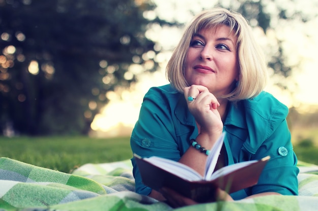 Femme allongée et lue livre soleil