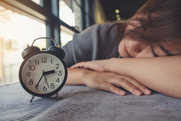 Photo femme allongée avec réveil