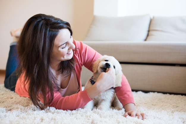 Femme allongée sur le sol avec un chiot