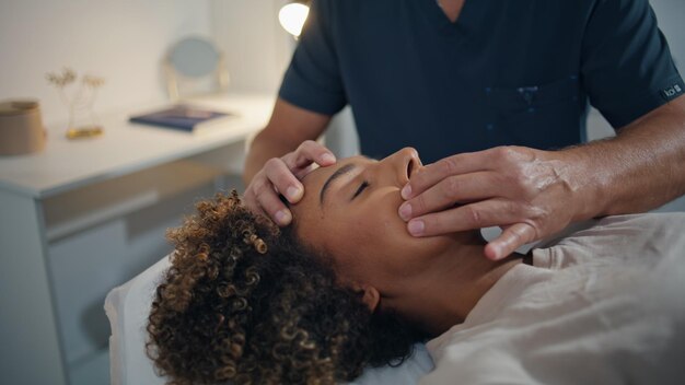 Femme allongée en thérapie chiropratique dans un centre de santé en gros plan homme médecin massant