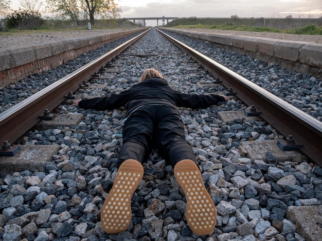 Femme allongée sur la voie ferrée
