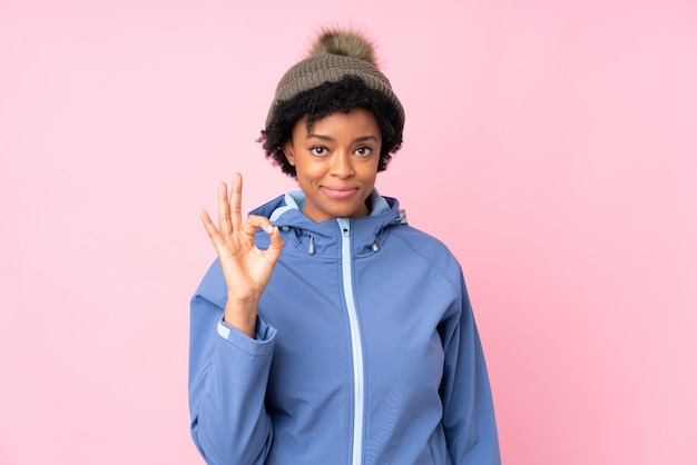 Photo femme américaine africaine, à, chapeau hiver, sur, mur rose