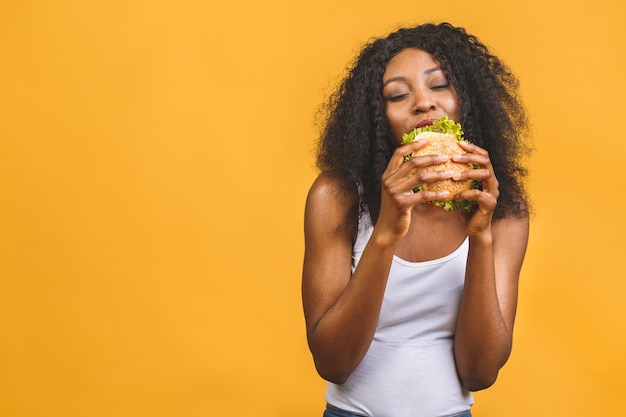 Femme américaine africaine, manger, hamburger