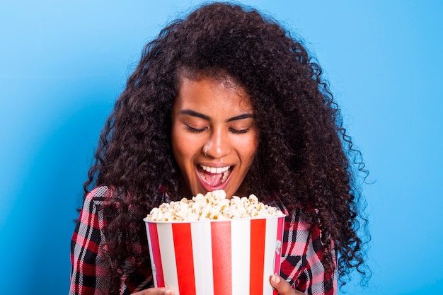 Femme américaine africaine, manger, pop-corn, heureux, à, grand sourire