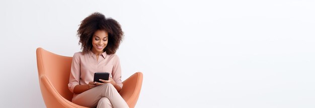 Une femme américaine joyeuse est assise à la maison dans un fauteuil et fait des achats sur Internet