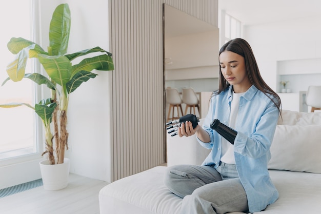 Femme amputée tenant la main en carbone et la connectant au bras Membre robotique électronique