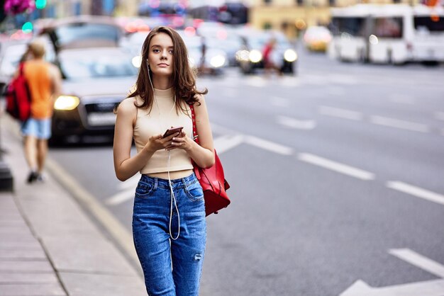 Une femme d'un an écoute de la musique à l'aide d'un smartphone et d'un casque