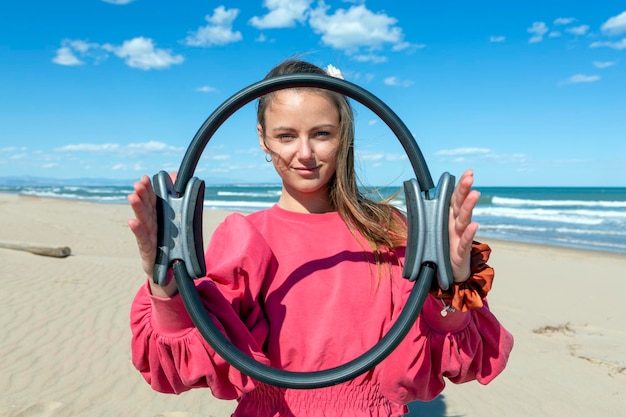 Femme avec anneau de pilates sur la plage