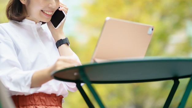 Femme anonyme à l'aide d'une tablette PC à l'extérieur