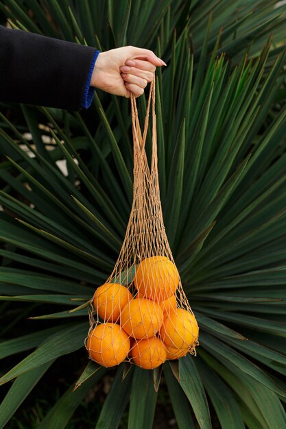 Femme anonyme tenant des oranges fraîches