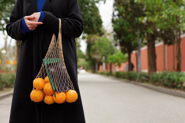 Femme anonyme tenant des oranges fraîches