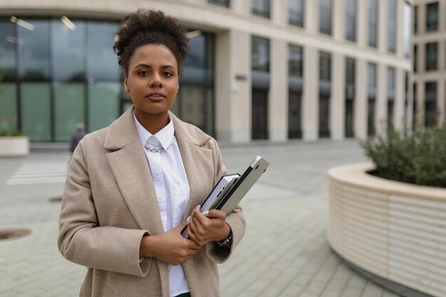 Une femme d'apparence afro-américaine, un fonctionnaire se tient dans le contexte d'un