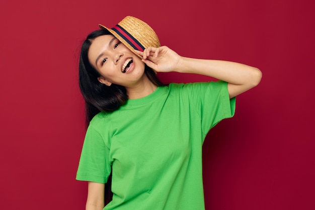 Femme d'apparence asiatique dans un t-shirt vert faisant des gestes avec ses mains amusant fond isolé unalt...