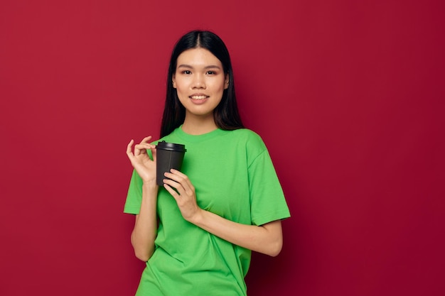 Femme à l'apparence asiatique posant dans un t-shirt vert modèle de studio de lunettes noires jetables inchangé