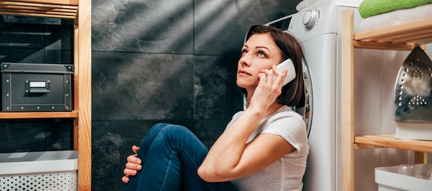 Femme appelant pour un service de réparation d'appareils