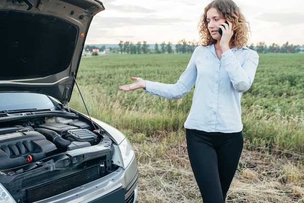 Femme appelle au service d'urgence, voiture cassée