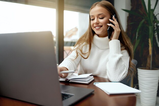 Une femme appelle pour parler et demander quelque chose en utilisant un ordinateur portable