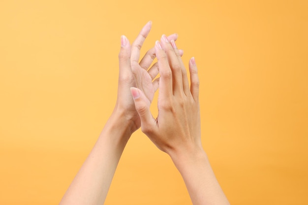 Femme applaudissant les mains isolées sur fond jaune