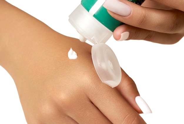 Femme appliquant une crème hydratante pour les mains et un soin de la peau de près