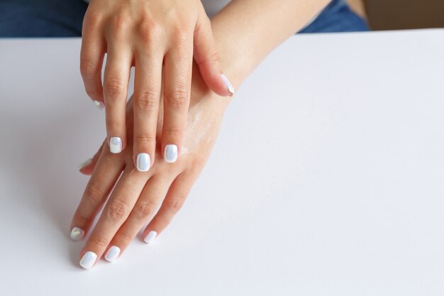 Femme appliquant une crème hydratante à ses mains