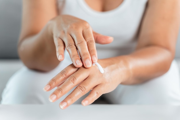 Femme appliquant une lotion hydratante pour le corps sur ses mains