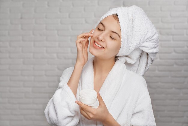 Femme appliquant sur le visage une crème naturelle pour hydrater