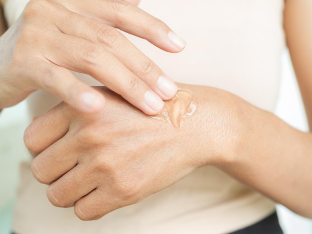 La femme applique la lotion de crème au gel d'aloe vera sur la peau du bras