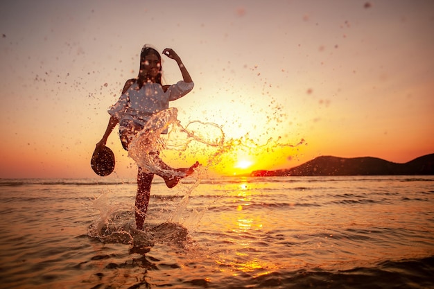 Femme appréciant le beau coucher de soleil sur la plage