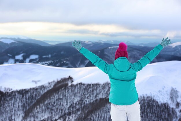 Femme appréciant la beauté de la station de montagne enneigée. Vacances d'hiver