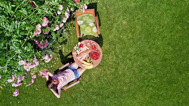 Femme appréciant la nourriture dans le beau jardin de roses