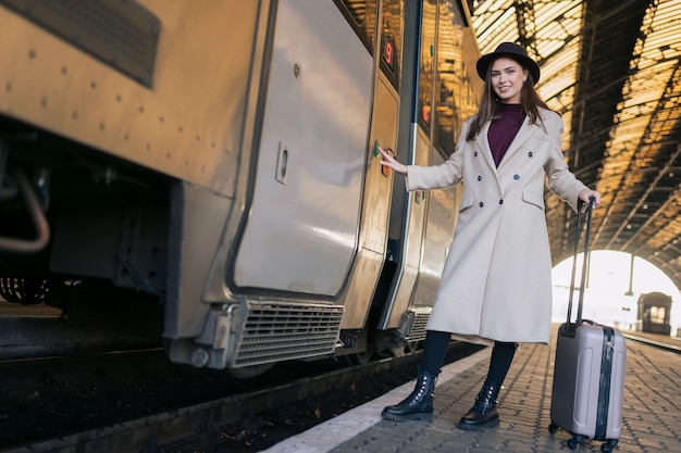 Femme appuie sur le bouton de la porte du train pour entrer.
