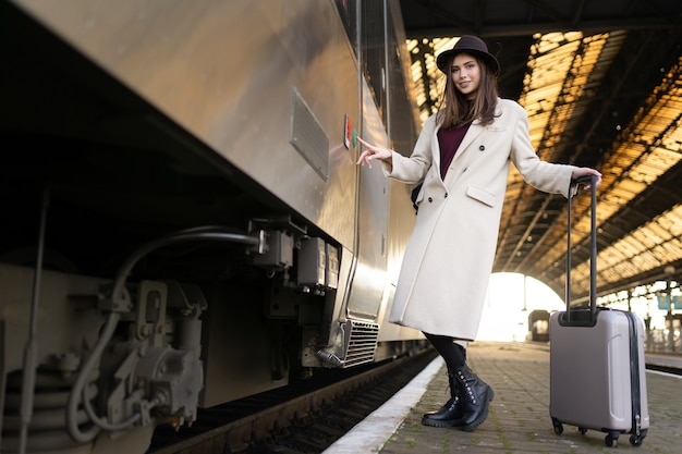 Une femme appuie sur le bouton de la porte du train pour entrer