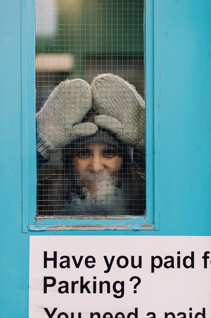 Photo une femme appuyée contre la fenêtre.