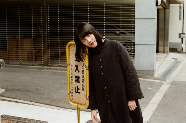 Photo une femme appuyée sur un panneau.