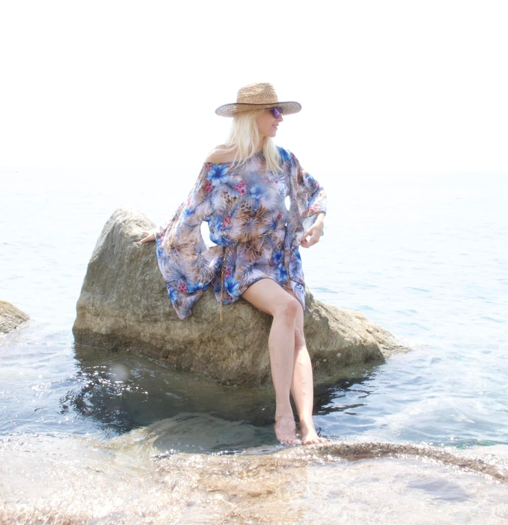 Photo une femme appuyée sur un rocher en mer