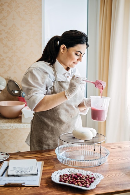 Femme arabe d'asie centrale chef pâtissier faisant gâteau mousse glaçure miroir femme moyen-orient