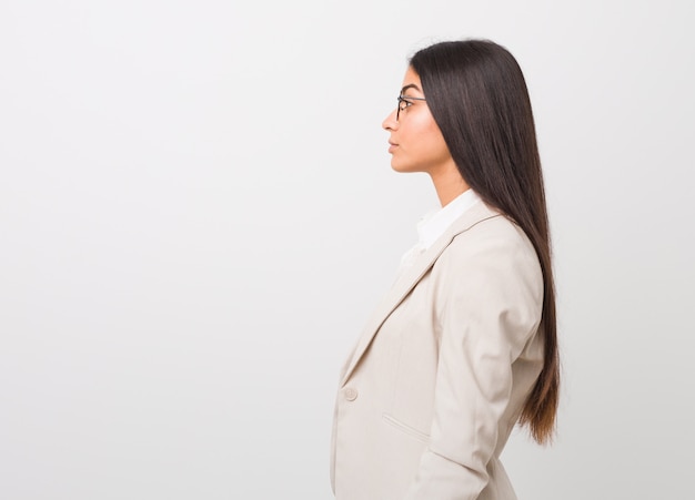 Femme arabe jeune entreprise isolée sur un fond blanc, regardant à gauche, pose sur le côté.