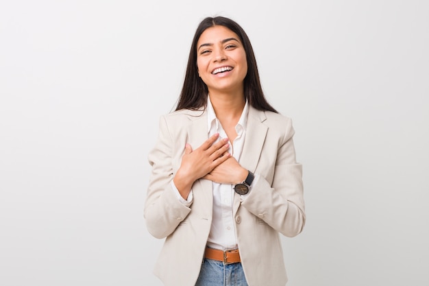 Femme arabe de jeunes entrepreneurs isolée sur un fond blanc en riant en gardant les mains sur le cœur, concept de bonheur.