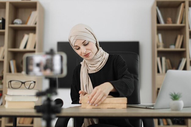 Femme arabe utilisant l'appareil photo d'un smartphone pour créer du contenu