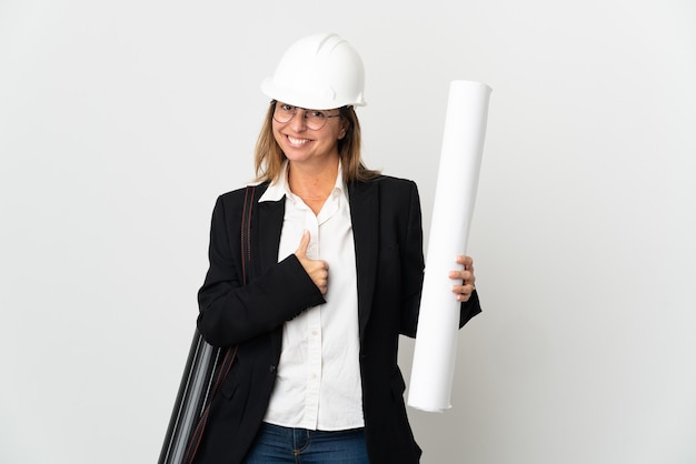 Femme d'architecte d'âge moyen avec casque et tenant des plans isolés