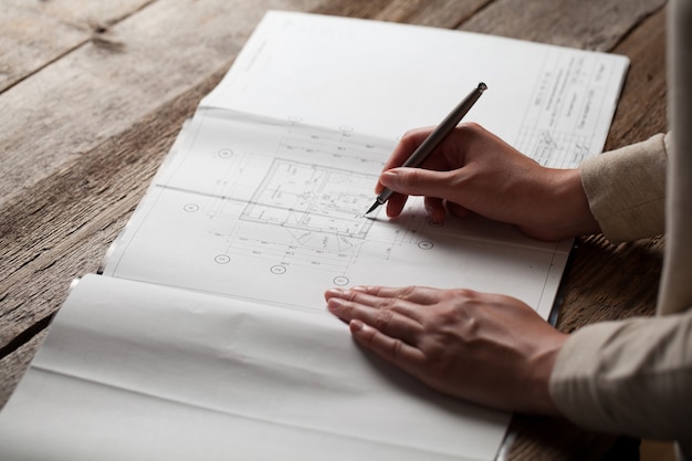 Femme d'architecte prenant des notes dans son plan de maison