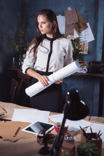 Femme architecte travaillant sur une table à dessin au bureau ou à la maison. Prise de vue en studio