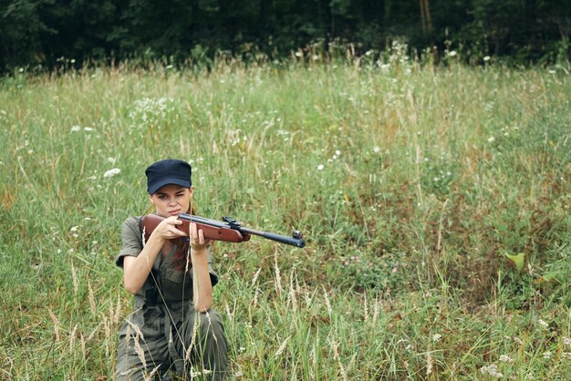 Une femme avec une arme dans ses mains sur un air frais vue accroupie