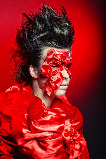 Femme avec art visage rouge créatif