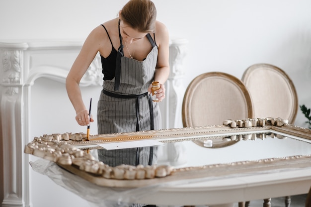 Femme artisan mains travaillant sur un grand cadre photo en bois