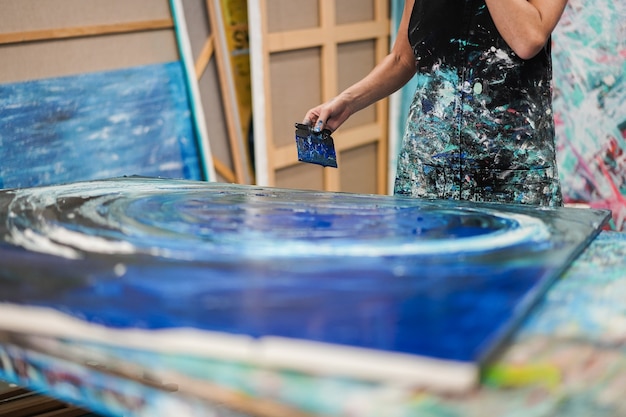 Femme artiste peignant à l'intérieur de son atelier à la maison - Focus on hand