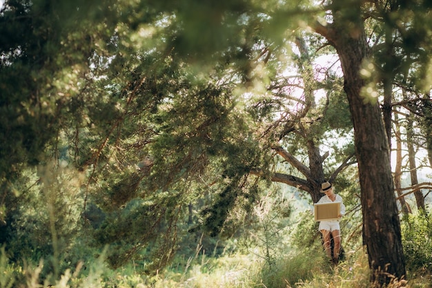 une femme artiste peint un tableau sous un arbre