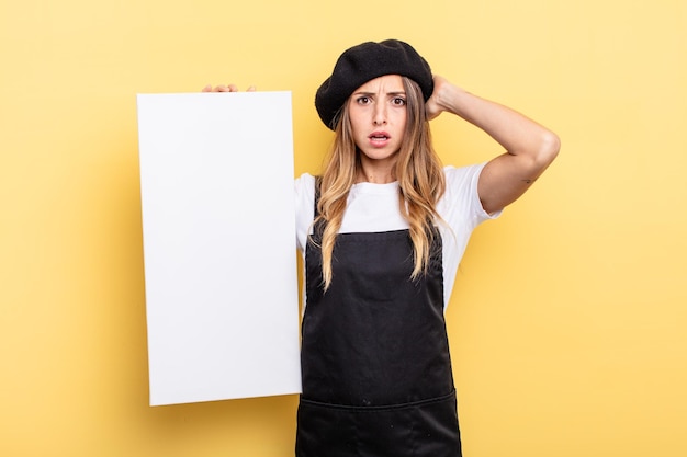 Femme artiste se sentant stressée, anxieuse ou effrayée, avec les mains sur la tête concept de toile vide